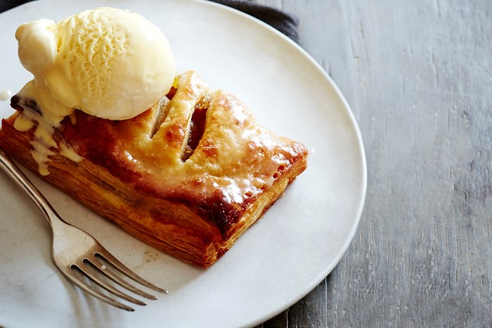 Apple turnover on a plate topped with ice cream