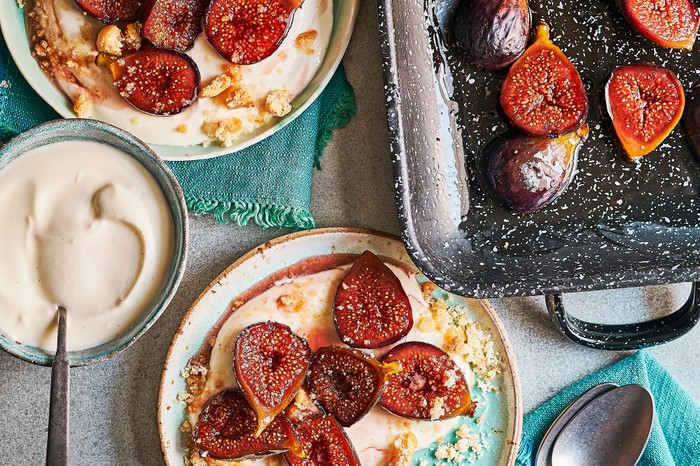 White plates topped with mascarpone and halves purple figs