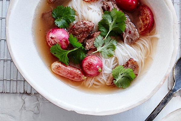 Beef Noodle Soup Recipe With Chilli and Radishes served in a deep white bowl on a marble surface