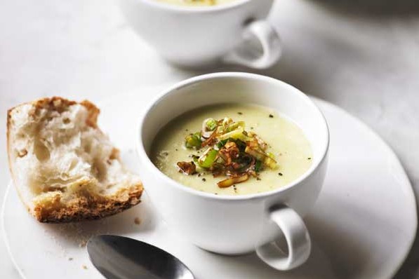 Three cups of leek and potato soup, topped with croutons