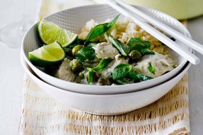 Thai green chicken curry in a bowl with a glass of wine