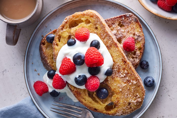 Stack of sourdough french toast with yogurt and berries on top