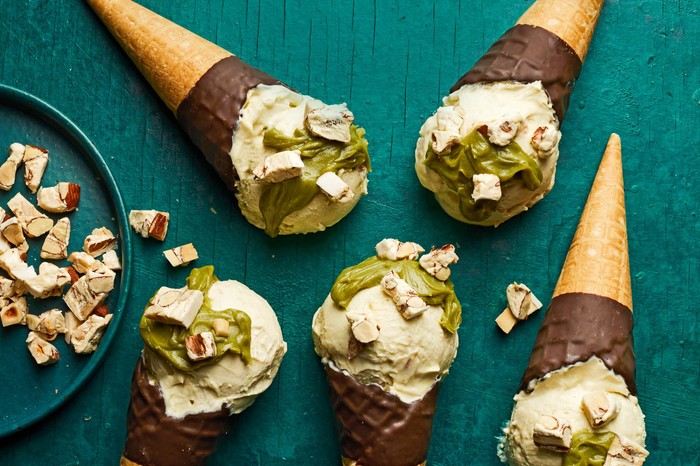 Chocolate-dipped cones of pistachio ice cream topped with nougat pieces