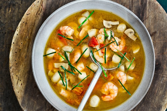 A bowl of tom yum soup with prawns