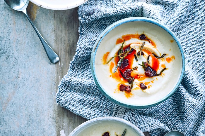 Two bowls of celeriac soup, topped with chorizo chunks and chorizo oil