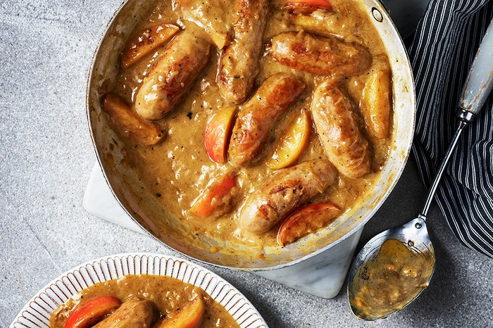 A casserole dish full of sausages in gravy